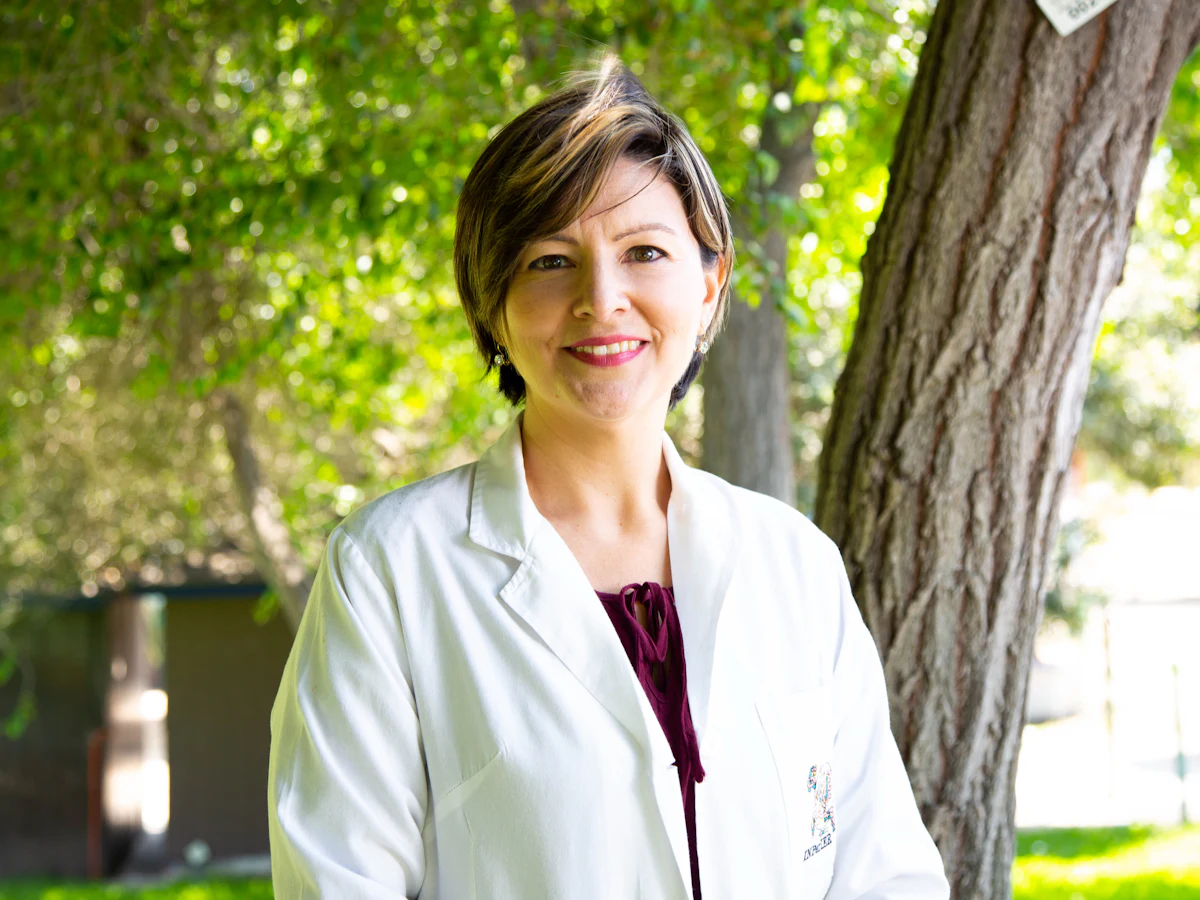 Médica sorrindo, de jaleco branco
